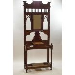 A Victorian oak hall stand with inset central mirror framed by spindle and fretwork decoration
