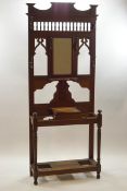 A Victorian oak hall stand with inset central mirror framed by spindle and fretwork decoration
