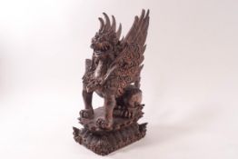 An Indonesian carved hardwood figure of a winged mythical beast,