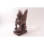 An Indonesian carved hardwood figure of a winged mythical beast,