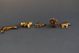 Five assorted 9 carat gold charms consisting of a Mouse, Cow, Tritan figure,