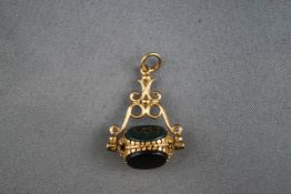 A hallmarked 9 carat gold triple swivel fob set with carnelian, onyx and bloodstone.
