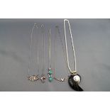 A selection of five miscellaneous pendants and necklaces to include one large shell pendant on