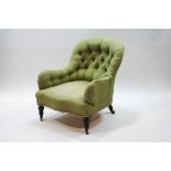 A Victorian button back armchair with turned ebonised legs and brass casters