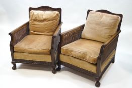 An early 20th century mahogany bergere suite, comprising a two seat sofa and a pair of armchairs,