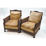 An early 20th century mahogany bergere suite, comprising a two seat sofa and a pair of armchairs,