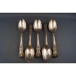 A set of four silver Kings pattern dessert spoons, each engraved with a monogram, London 1864,