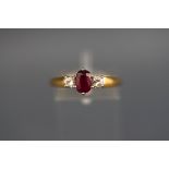 A hallmarked 18ct gold three stone ring set with an oval ruby measuring 6.5mm x 4.5m.