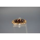 A yellow gold three stone garnet ring. hallmarked 9ct, Birmingham, 1971 'PDL' 2.