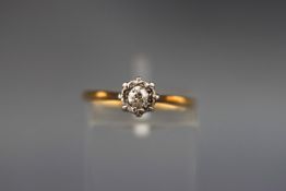 A yellow and white metal single stone diamond ring.