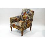 A late Victorian armchair with floral patterned upholstery on oak tapering legs,