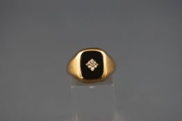 A hallmarked 9ct gold signet ring set with onyx and a central illusion set diamond. Gross weight: 5.