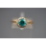 A hallmarked 18ct gold cluster ring set with a round blue zircon measuring 6.