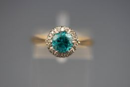 A hallmarked 18ct gold cluster ring set with a round blue zircon measuring 6.