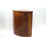 A mahogany standing corner cabinet, with one drawer above two panelled doors,