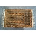 A small Middle Eastern rug with narrow repeating geometric borders on a reddish brown ground,