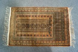 A small Middle Eastern rug with narrow repeating geometric borders on a reddish brown ground,
