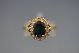 A hallmarked 18ct gold cluster ring set with an oval sapphire measuring 9.10mm x 7.00mm.