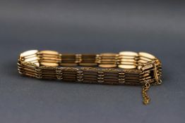 A hallmarked 9ct gold five bar bracelet having a filigree scroll engraved design to the outer links.