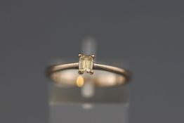 A hallmarked 18ct white gold single stone diamond ring set with an emerald cut diamond measuring