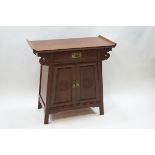 A 20th century Chinese side table with one drawer above two cupboard doors,