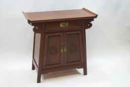 A 20th century Chinese side table with one drawer above two cupboard doors,