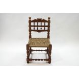 An oak child's chair with spindle back, turned and block supports, with a woven seat,