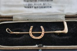 A 9 carat gold hunting crop and horse shoe stock pin, boxed. Hallmarked 9ct gold, Birmingham, 1972.