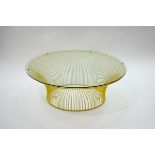 A modern yellow painted metal coffee table, of slatted circular form with glass top,