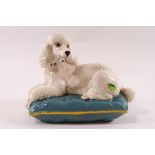 A Beswick model of a poodle lying on its bed, circular printed factory mark to base, 14cm high,