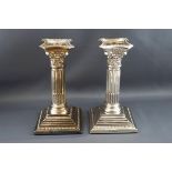 A pair of silver Corinthian column candlesticks, each with detachable sconces on stepped bases,