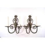 A pair of wrought metal two branch wall lights with green and gilt finish,