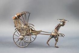 A Chinese white metal model of a man pulling a rickshaw, 5cm high,