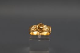 A hallmarked 18 carat gold buckle ring with engine turned design. Gross weight: 4.