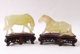 A pair of Chinese green hardstone figures of horses, one in kneeling position,