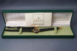 Gucci, a lady's wrist watch, on a leather strap,