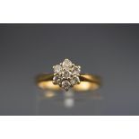 A hallmarked 18ct gold flower cluster ring set with seven round brilliant cut diamonds.