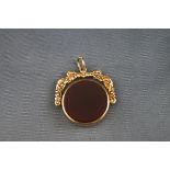 A hallmarked 9 carat gold swivel fob pendant set with carnelian and agate. Scroll design.