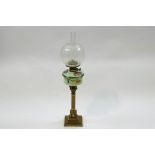 A Victorian brass Corinthian column oil lamp with painted glass reservoir and etched globe shade,