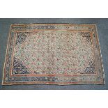 A small Persian style rug with botech design to the central field within alternating borders on a
