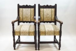 A pair of Victorian carved oak elbow chairs on turned and block legs,