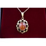 A hallmarked 9 carat gold pendant set with an oval cabochon cut sunstone measuring approximately 10.