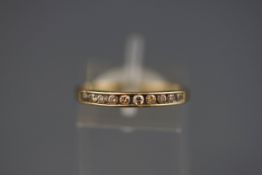 A hallmarked 9ct gold half hoop ring set with ten round brilliant cut diamonds.