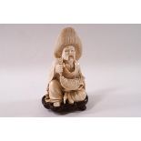 An early 20th century Japanese ivory figure of a fisherman seated with his catch,