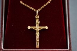 A boxed hallmarked 9 carat gold crucifix pendant, suspended from a twisted rope chain,