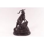 A 20th century bronze of a goat on a rocky outcrop on an oval slate base,