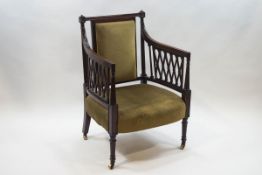 A 19th century mahogany elbow chair with upholstered back and seat and pierced lattice arms,