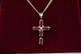 A hallmarked 9ct gold cross pendant set with five marquise cut garnet (5.8mm x 3.
