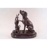 A 20th century bronze of a seated dog and dead hare on oval slate base,