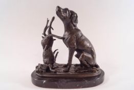 A 20th century bronze of a seated dog and dead hare on oval slate base,